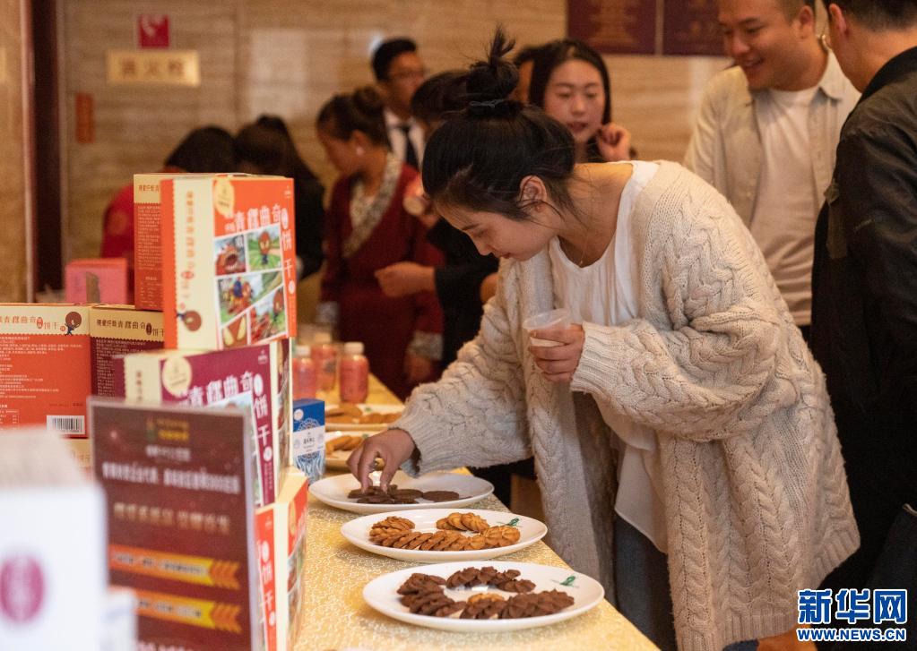 在拉萨举办的青稞深加工产品发布会现场,一名嘉宾在试吃青稞饼干(2019